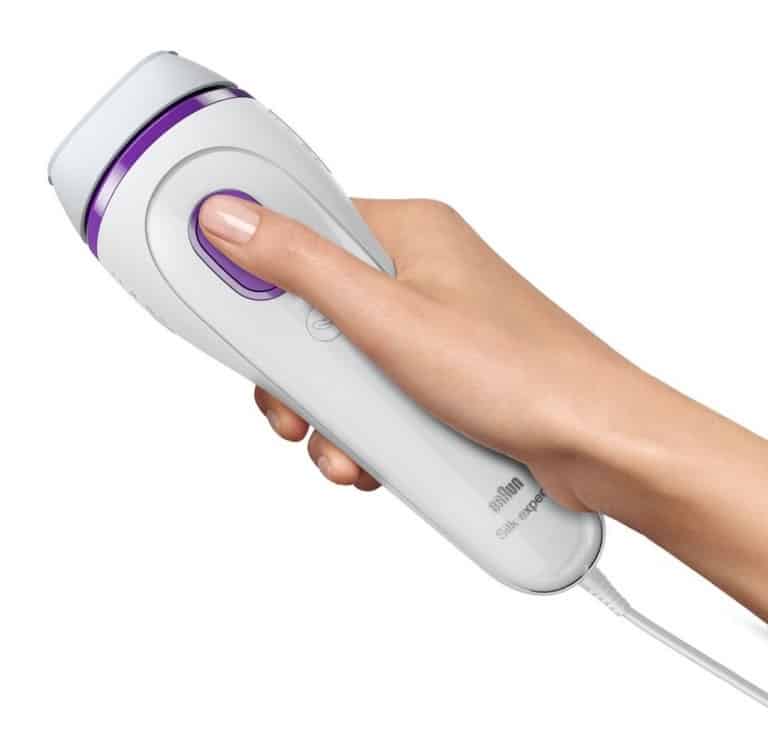 Hand holding the Silk Expert 3 with their thumb on the flash button.