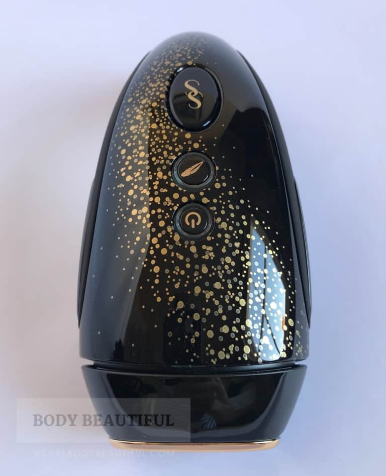 Close up photo of the Muse device showing the speckled gold pattern swooshing over the glossy top of the device