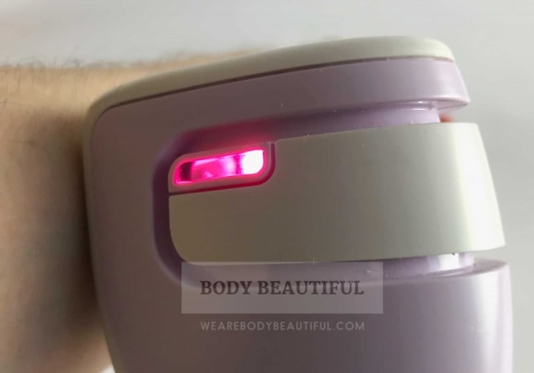 Close up photo of the bright pink contact light on the Tria age Defying laser