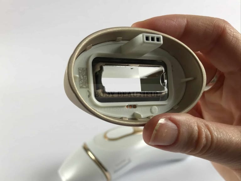 close up photo of the back of the body attachment showing the mirrored recessed light exit window and the small plug to fit in the IPL device.