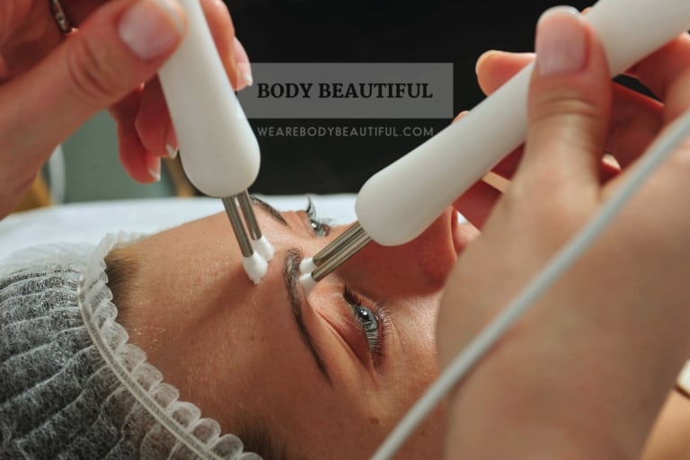 Close up photo of a microcurrent facial with the electrical probes lifting the eyebrow area.