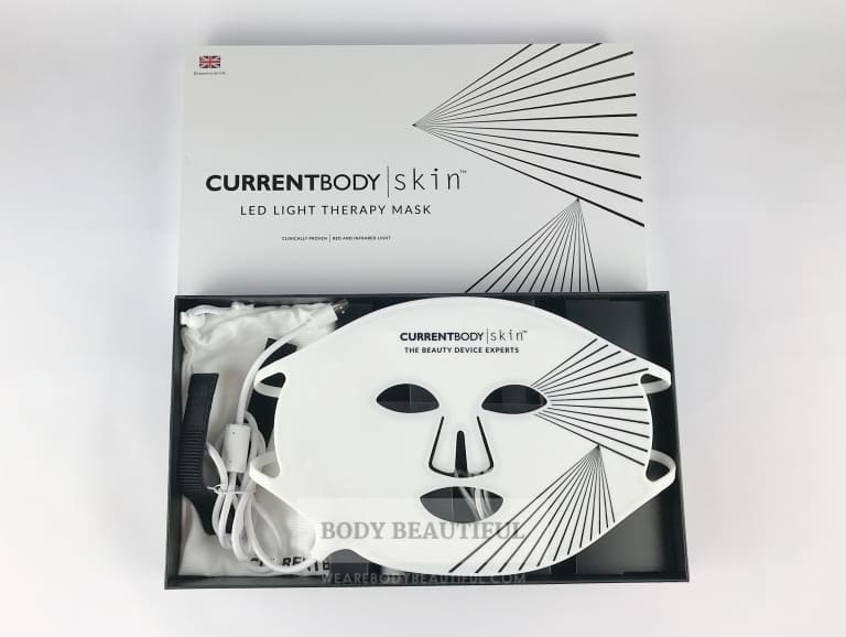 The white id removed from the 
CurrentBody.com Skin LED light therapy mask box to reveal the white silicone mask.