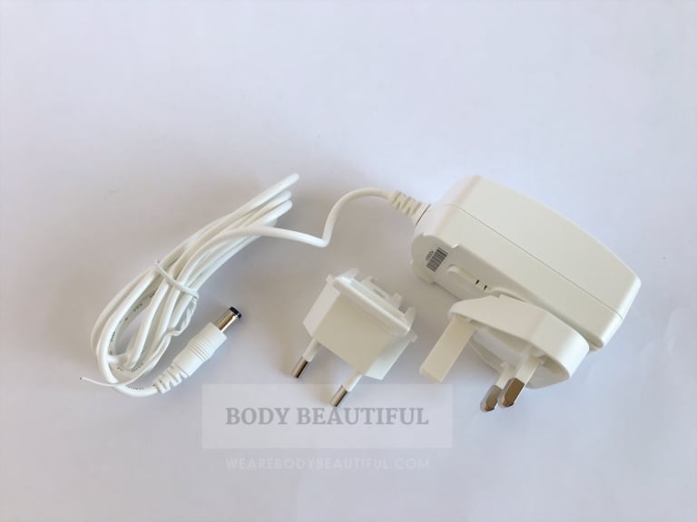 Top-down photo of the white light-weight power cable with inter-changeable UK and European plug adaptor.