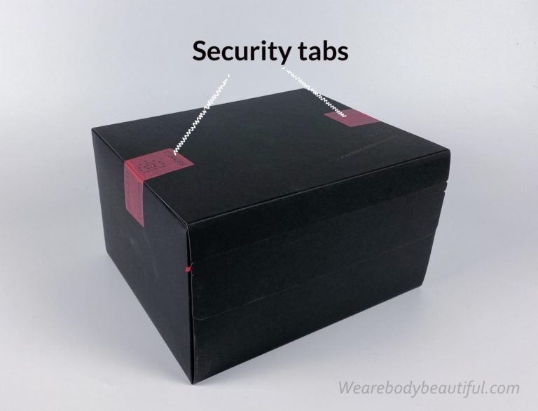 A small/medium-size black card board clad box with red security tabs