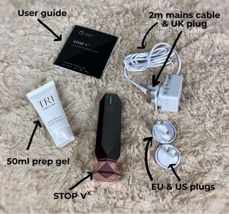 The contents of the Tripollar VX home RF kit laying in a floofy cream throw: the STOP VX device, 50 ml prep gel, user guide, 2m mains cable, UK, EU and US plugs.