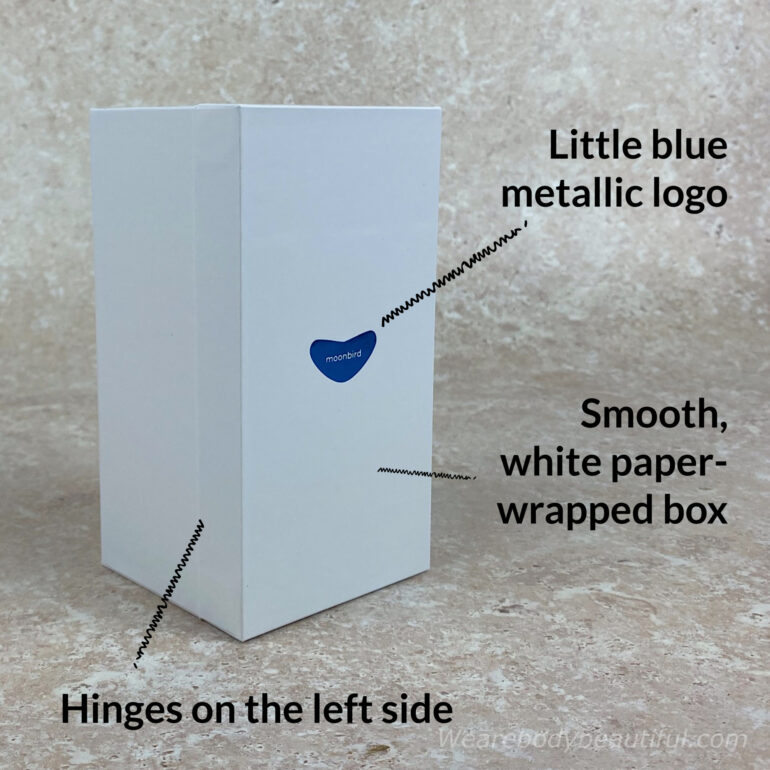 The information sleeve slides off to reveal a smooth white paper wrapped box with a metallic blue Moonbird logo on the front. The lid hinges on the left-hand side.