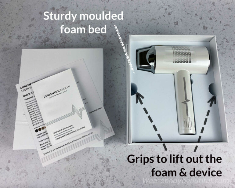 Under the guide is the laser device laying on its side, secured in a sturdy white moulded foam bed. Use the semicircle grips on opposite edges to lift out the foam and device.
