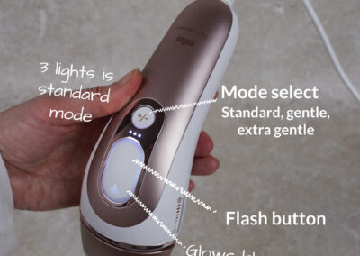 The Pro 7 IPL held in my hand showing the large flash button on top, and next to that the 3 small white LED lights showing it's in standard power mode, with the mode select button next to it. There are 3 modes, standard, sensitive and extra sensitive. The flash button glows blue around the edges when the app is connected.