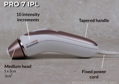 Side view of the Pro 7 IPL device showing the fixed power cord, the tapered handle, 10 intensity increments on the side power bar, and the medium flash head attached. It's 1 by 3 cm (3cm2).